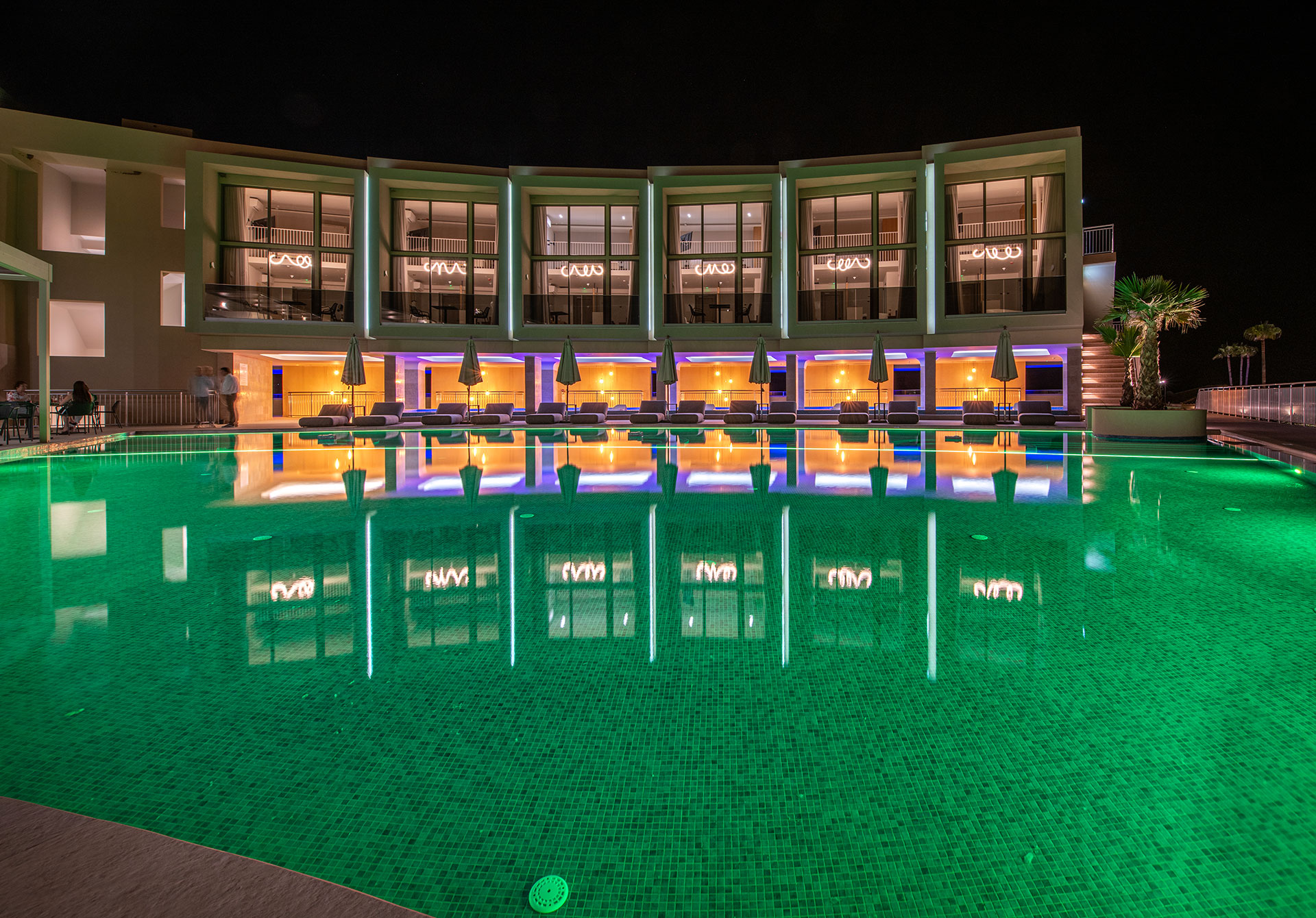 Ventale Island Breeze Resort pool view and the resort in the background lit up at night